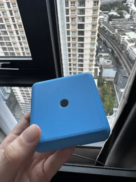 Hand-held DoggyBell detector prototype in a blue enclosure with a circular microphone opening.